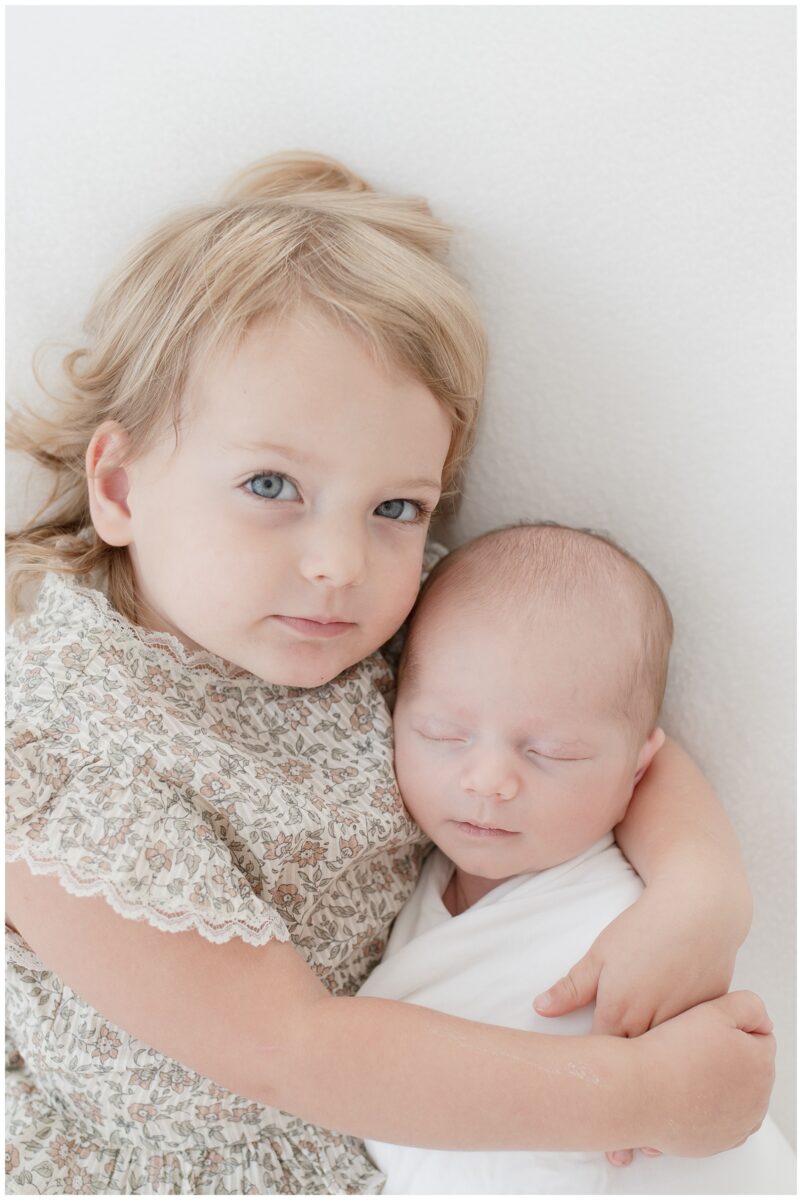 big sister holding her baby brother for newborn session