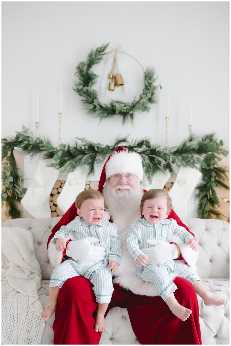 twin boys crying on santa's lap in photo session